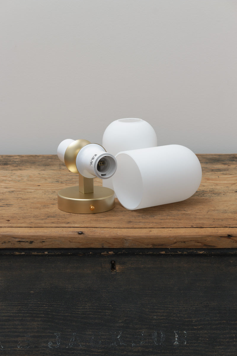 trunk shot of Carlisle Double Glass Wall Light in brass gold with two opal glass shades. 