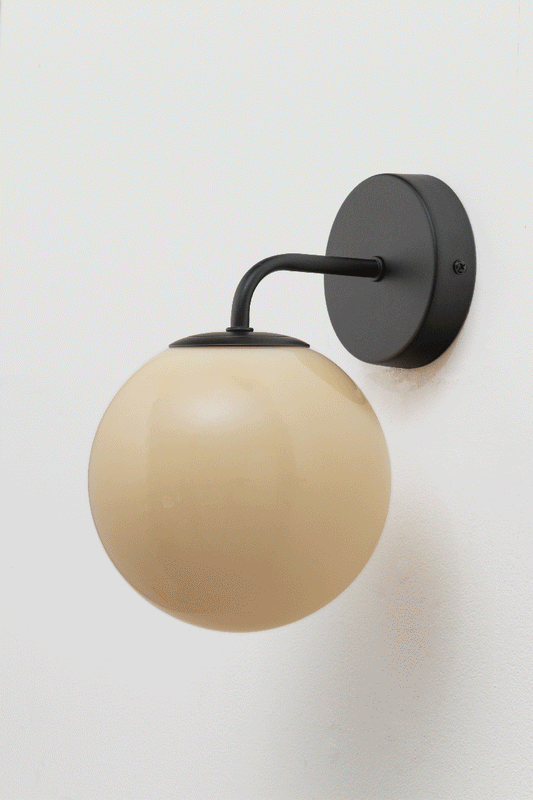 Boise Amber Glass Wall Light with black curved arm and round wall plate, featuring a warm amber glass ball shade.