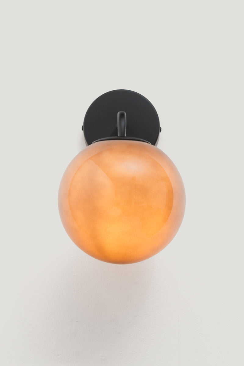 Boise Dark Grey Glass Wall Light illuminated, showcasing the rich smoked glass and warm ambient glow.