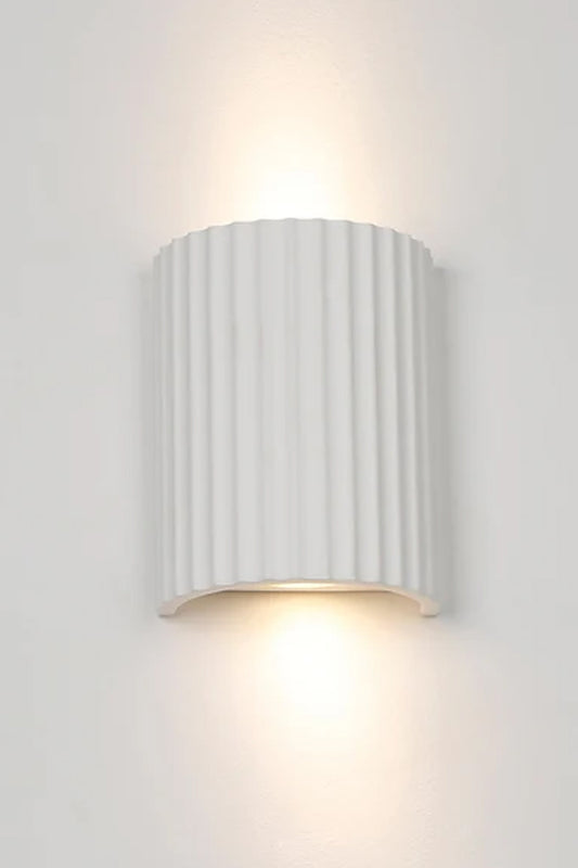 White Raynes Plaster Wall Light illuminated with warm light cast upwards and downwards