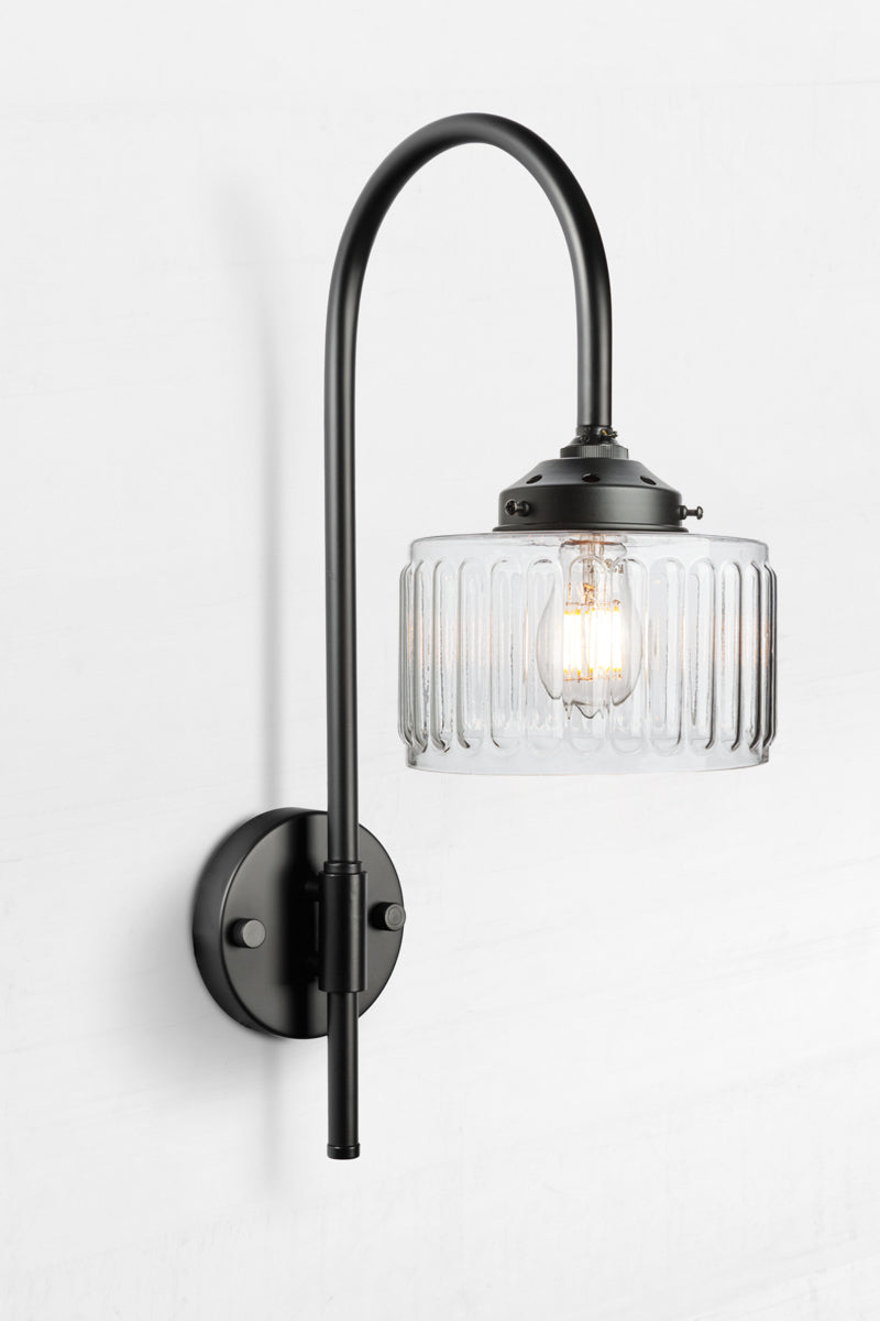 Black shepherds hook wall light paired with a clear glass shade. 