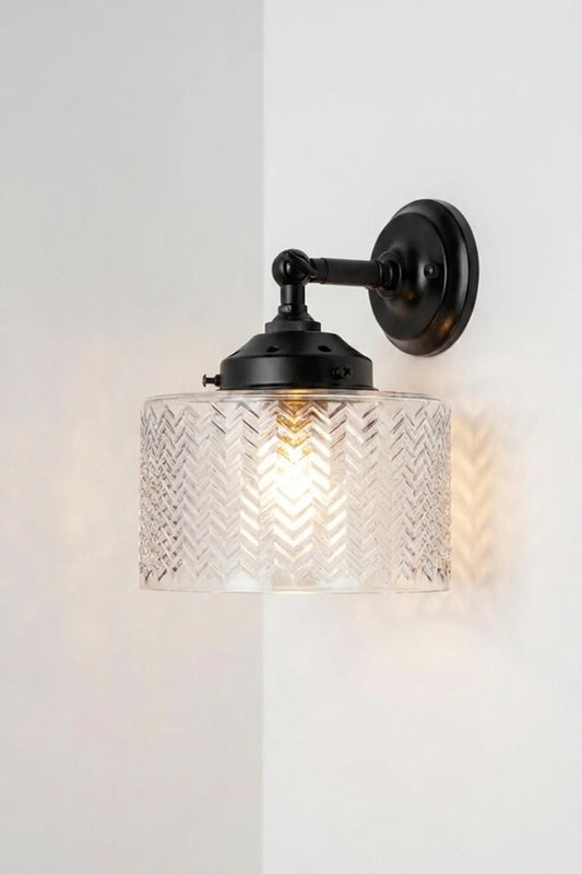 Malibu Glass Swivel Wall Light in black with clear textured glass shade mounted on a white wall.