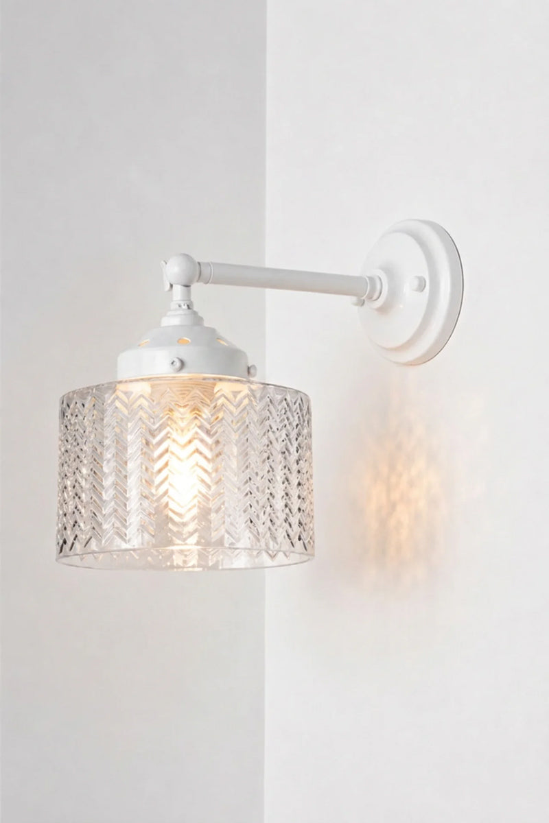 Illuminated Malibu Glass Swivel Wall Light with a long, white arm with a clear textured glass shade.