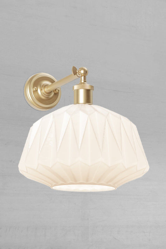 Art deco inspired opal glass shade on a long gold/brass straight arm wall sconce with swivel lampholder