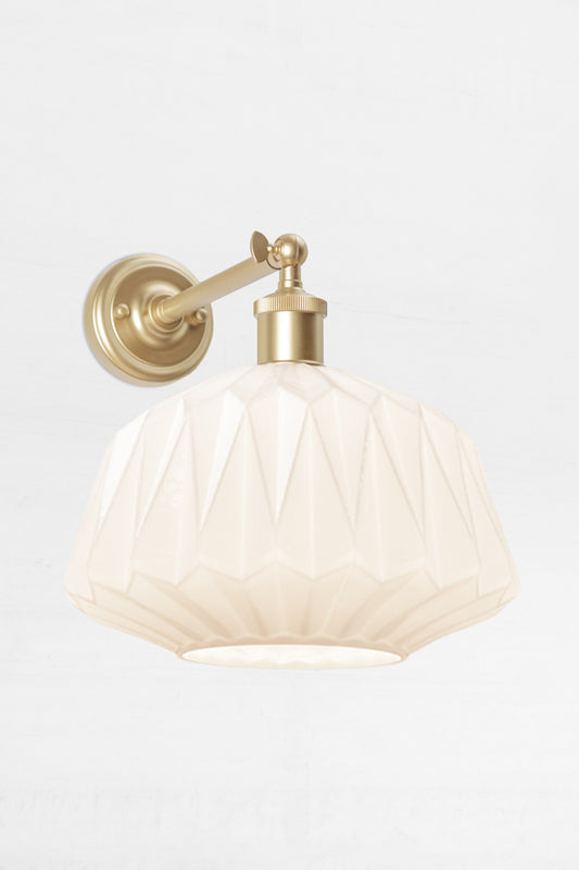 Art deco inspired opal glass shade on a long gold/brass straight arm wall sconce with swivel lampholder
