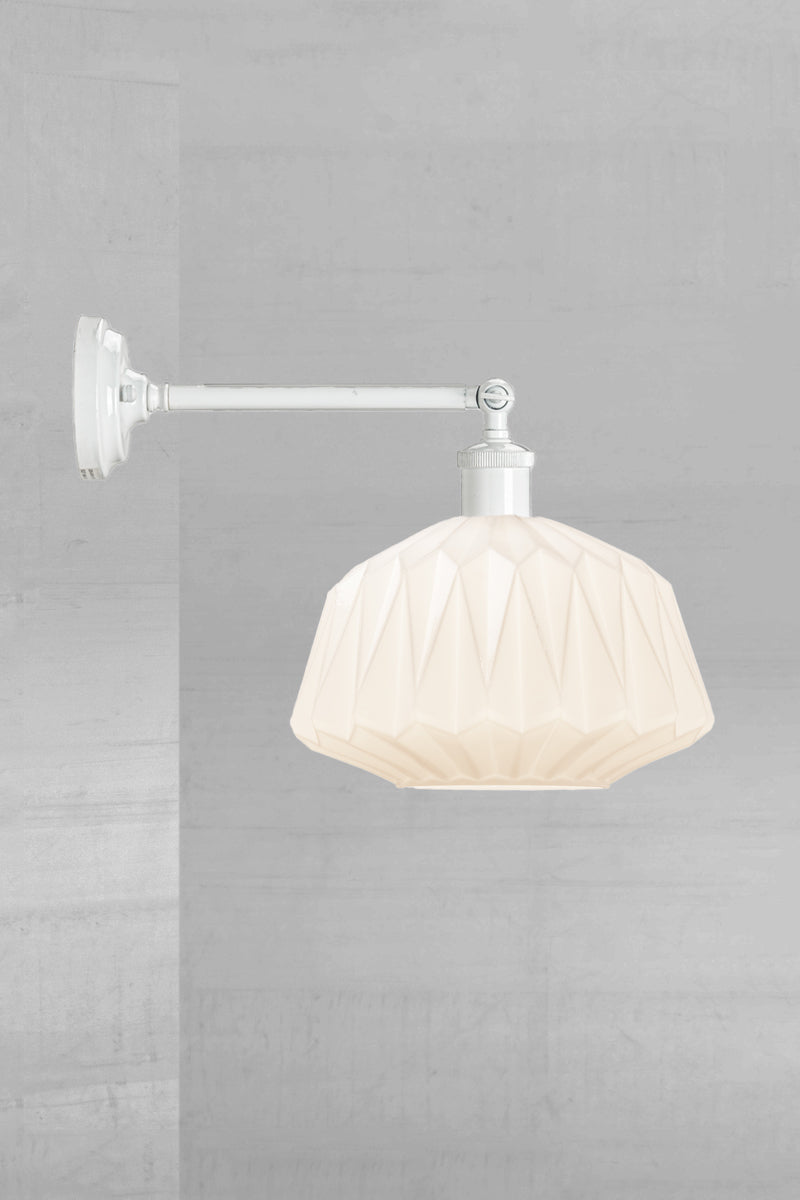 Art deco inspired opal glass shade on a long white straight arm wall sconce with swivel lampholder