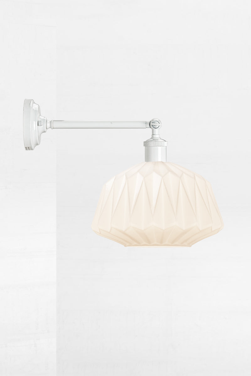 Art deco inspired opal glass shade on a long white straight arm wall sconce with swivel lampholder