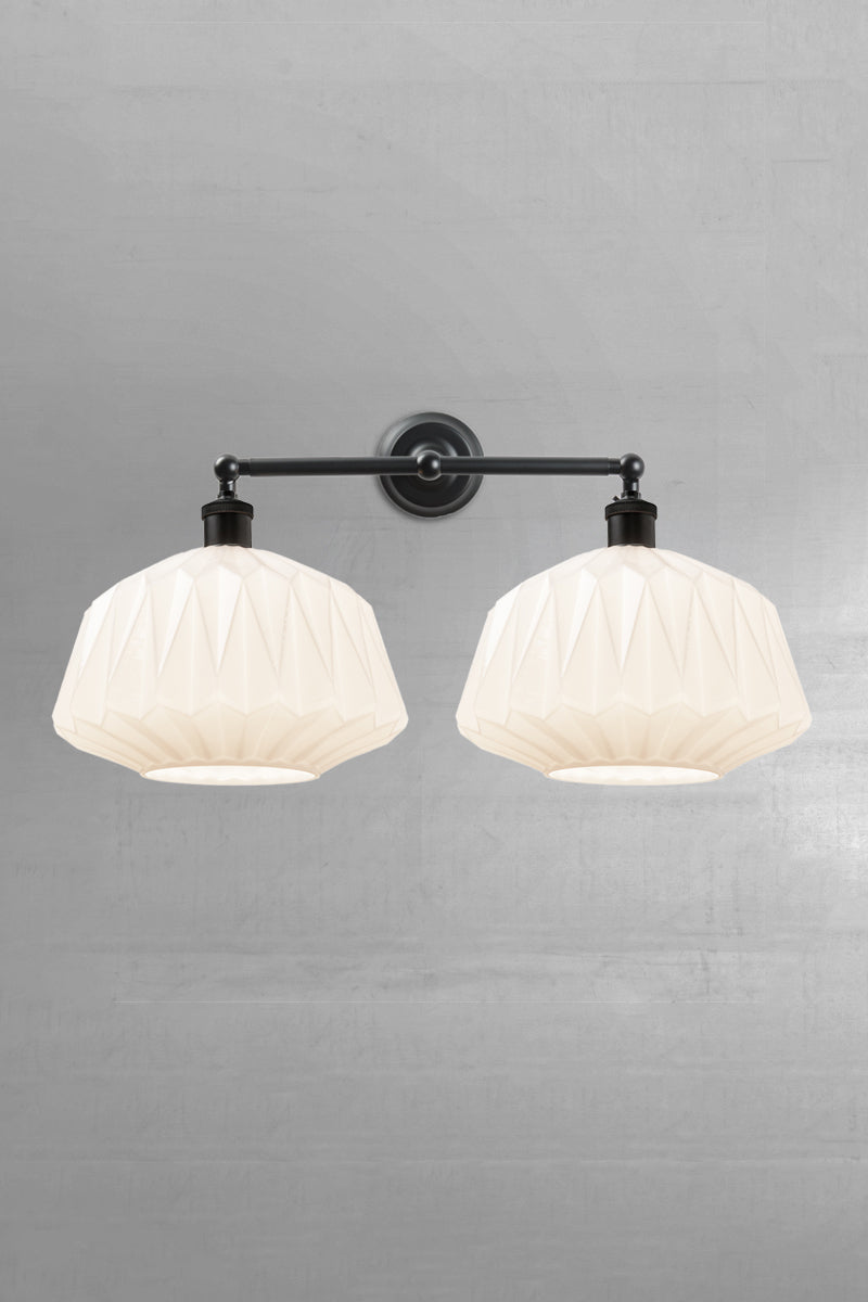 Two opal glass shades with geometric design on a black double swivel wall sconce 