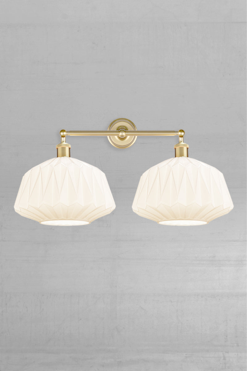Two opal glass shades with geometric design on a gold/brass double swivel wall sconce 