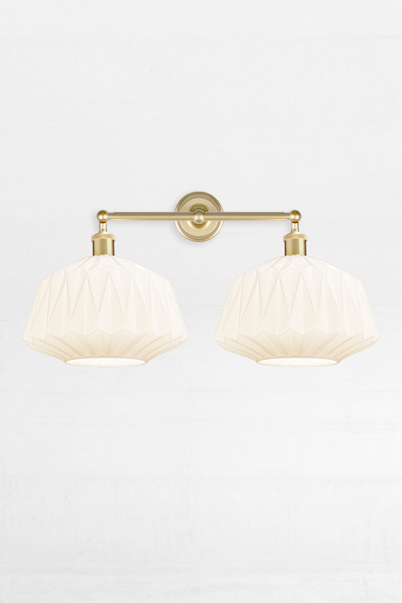 Two opal glass shades with geometric design on a gold/brass double swivel wall sconce 