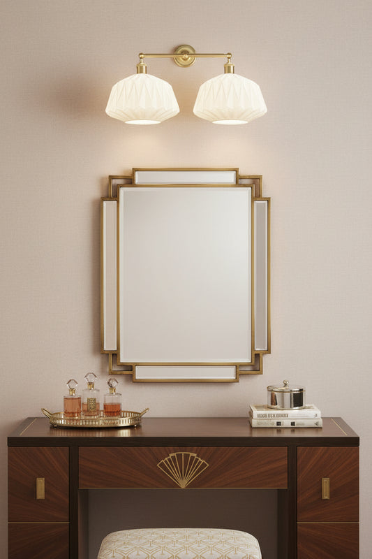 Gold/brass double light wall sconce with opal glass shades in an art deco inspired dressing room. 