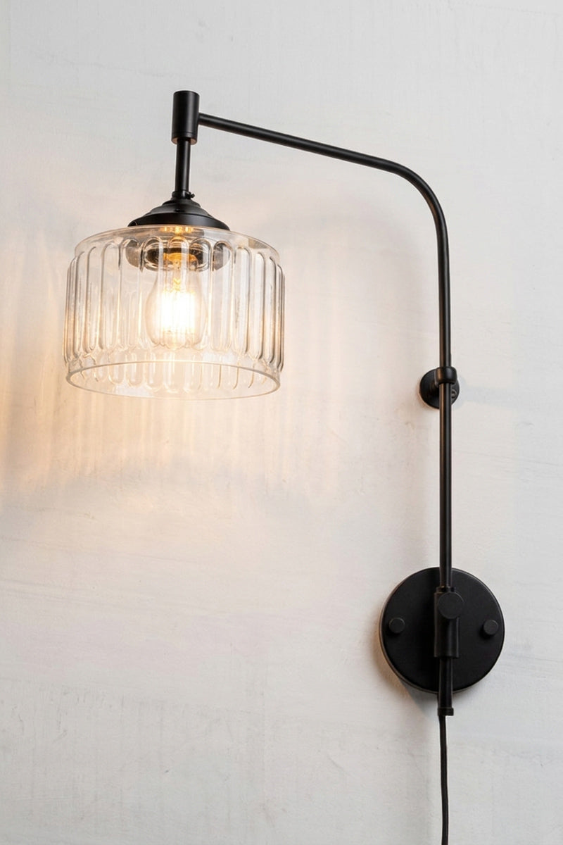 Capri Glass Wing Arm Wall Lamp with clear fluted glass shade and extended matt black wing arm with plug in cord. 