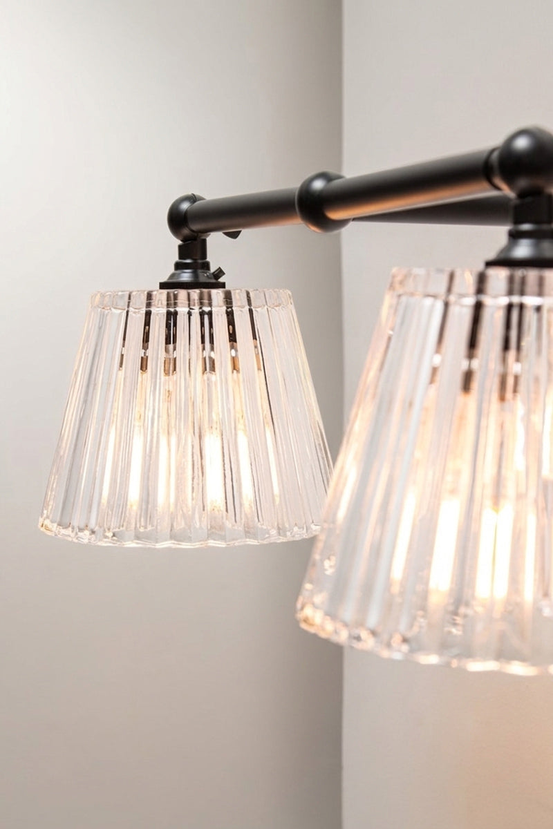 Close-up of black Davis Double Swivel Arm Wall Light with textured clear glass shades