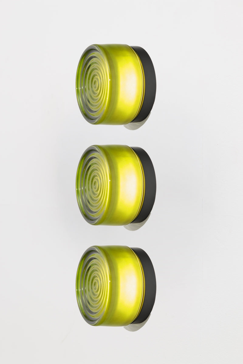 Side profile view of three green LED glass wall lights with vibrant illuminated green glass shades.