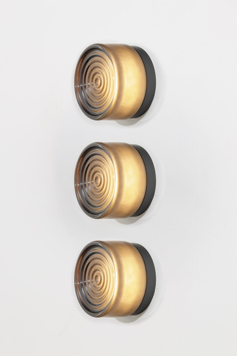 Side profile of three grey LED glass wall lights highlighting the smoked glass finish and layered concentric detailing.