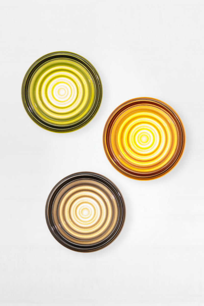 Flat lay arrangement of amber, green and grey LED glass wall lights showing mixed finish bundle options.