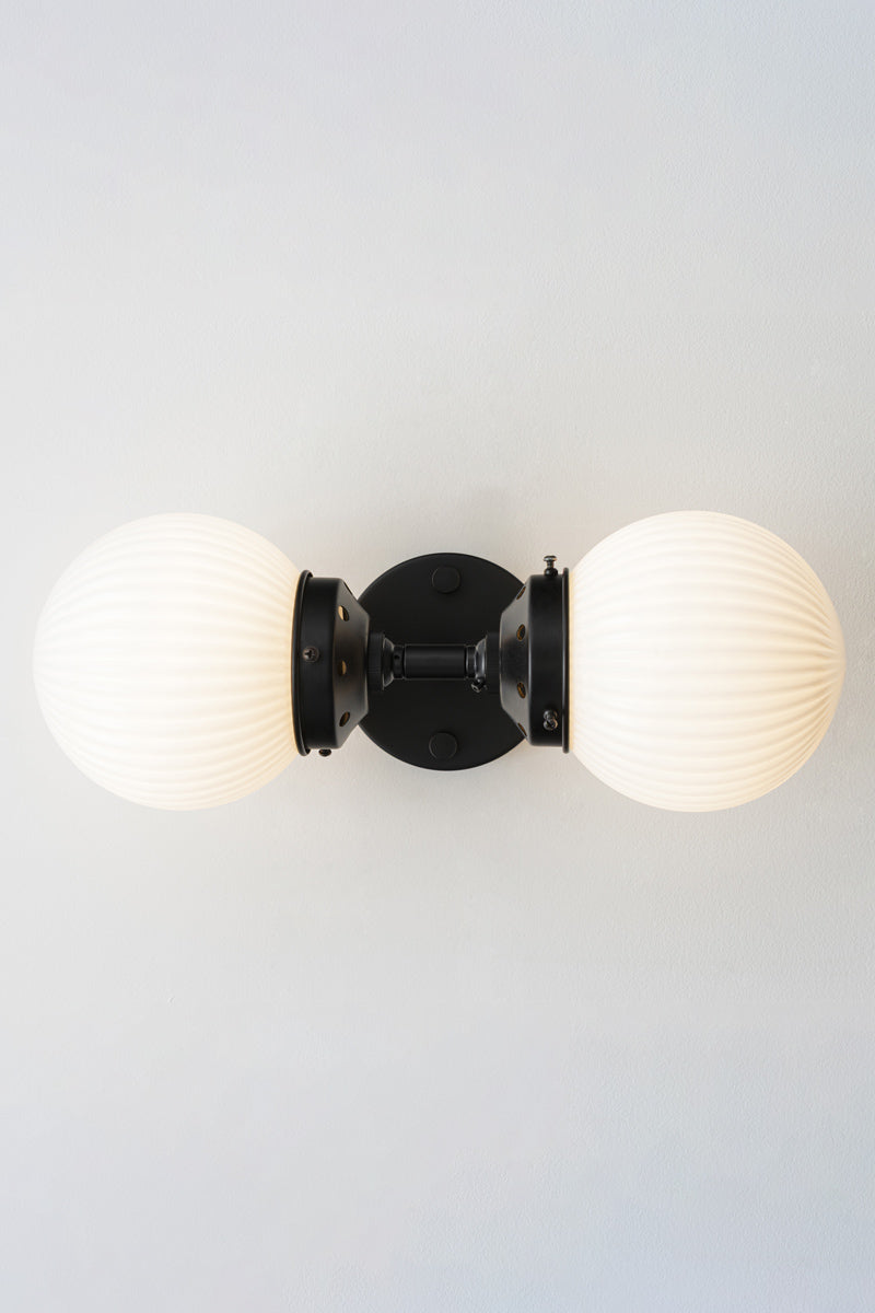 Dakota Reeded Glass Double Light Wall Sconce with opal shades sitting horizontally