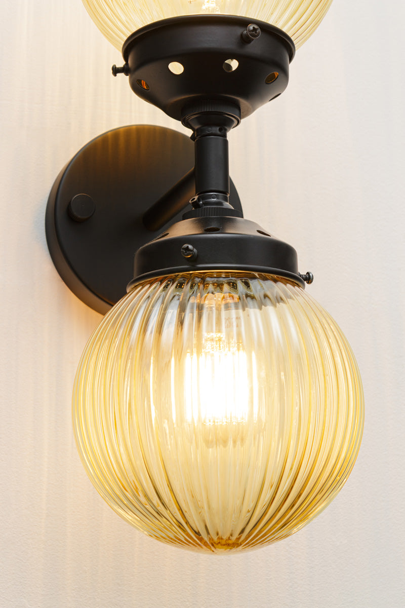 amber reeded glass shade on black wall sconce