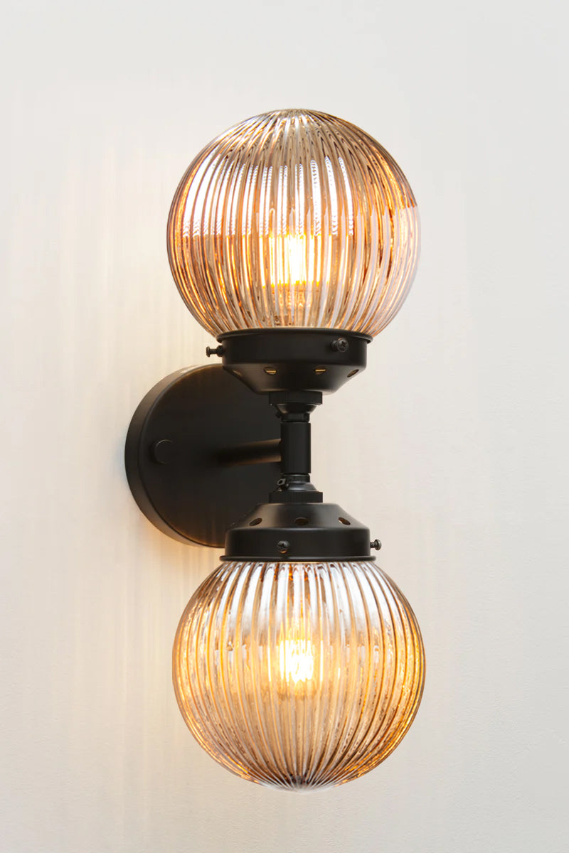 Dakota Reeded Glass Double Light on a black Wall Sconce with dark amber shades on each end