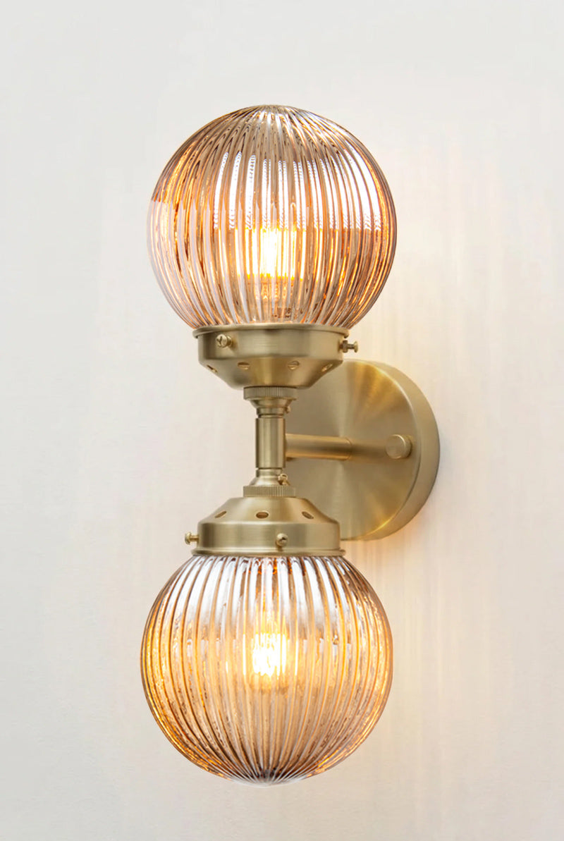 Dakota Reeded Glass Double Light on a gold/brass Wall Sconce with dark amber shades on each end
