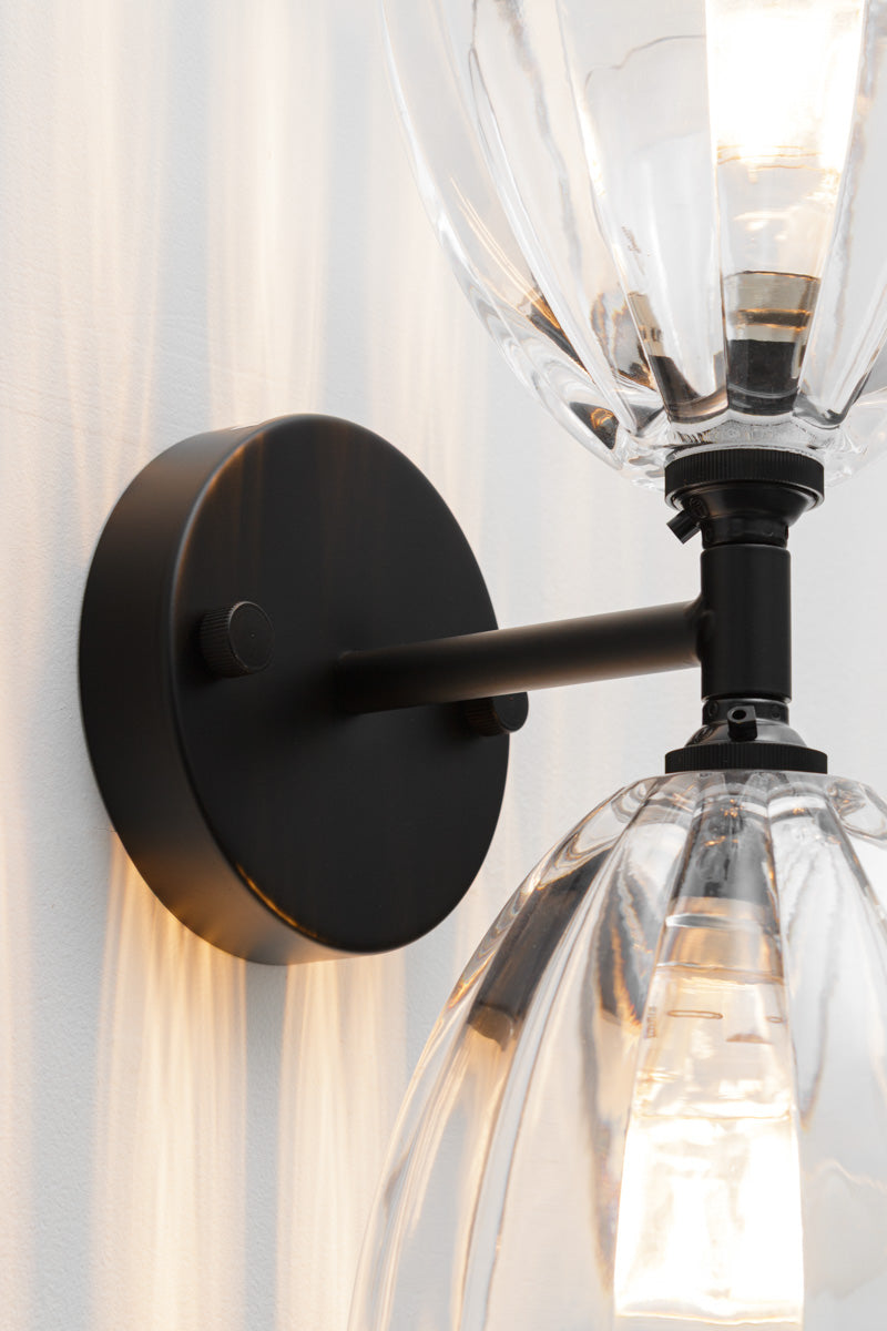 Close up of the black up/down double wall sconce with it's two clear glass shades. 