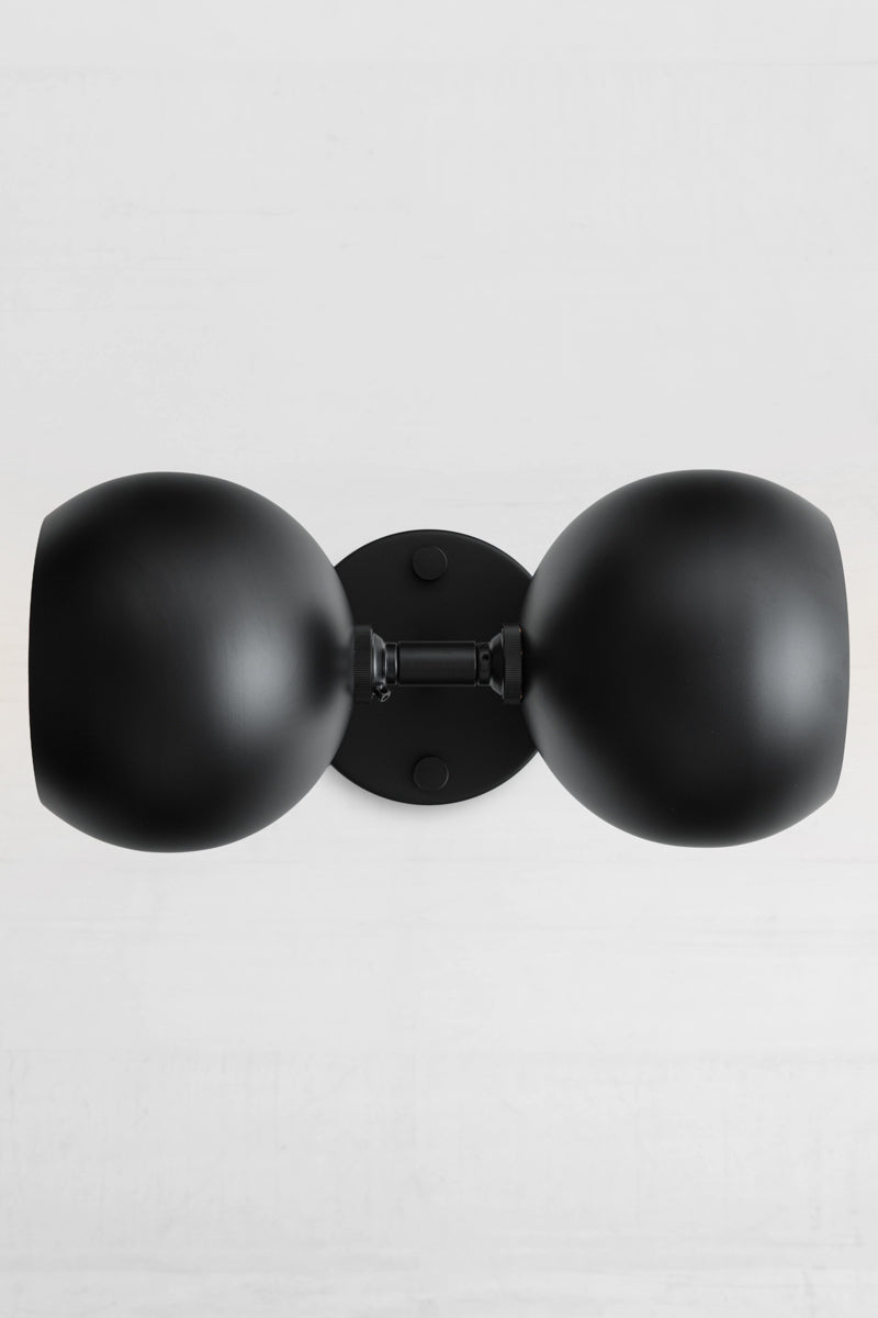Sideways installation og the black double wall sconce with two steel bulb shades in black.