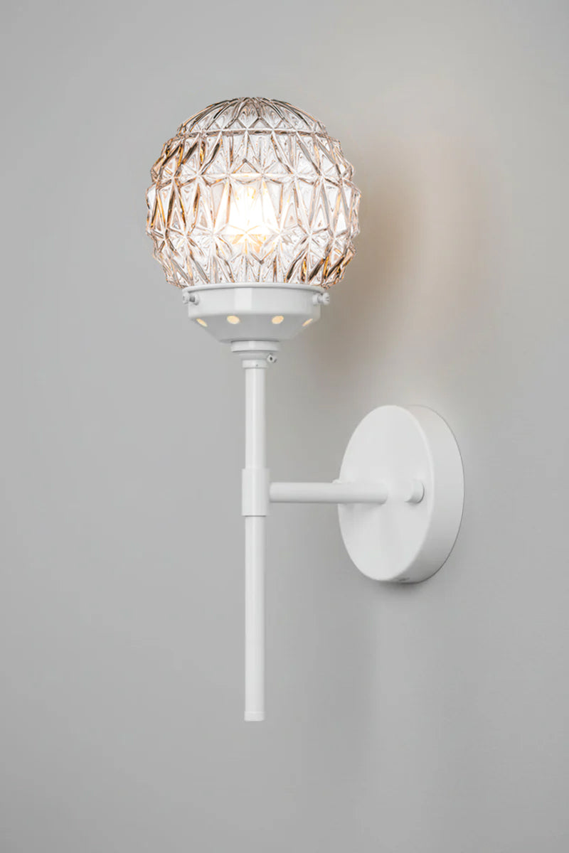 Clear glass ball shades with diamon-cut detailing paired with a white steel stem wall sconce. 