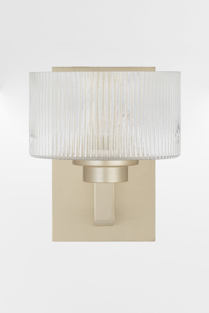 Front view of the wall sconce in Antique Silver with a rectangular mount plate and arm, holding a clear reeded cylindrical glass shade.