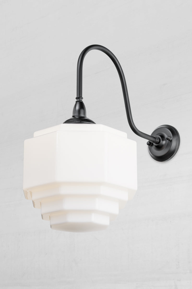 Stepped opal glass shade paired with an oversized black gooseneck wall arm with a bakelite gallery.