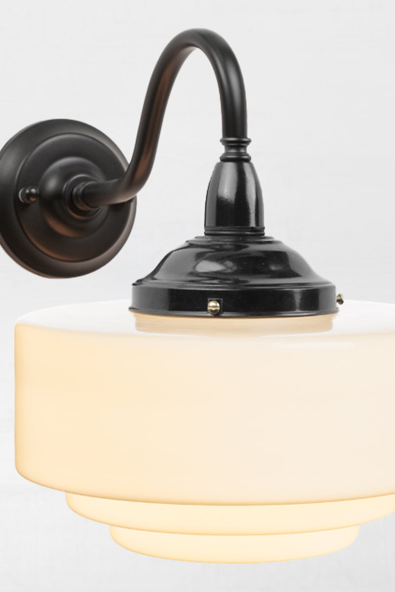 Close up of the black bakelite gallery and black metal gooseneck arm of the wall light. 