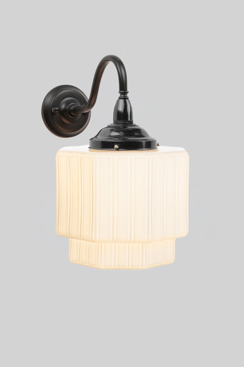 Outdoor wall light with art deco influence with an opal glass shade and black arm. 