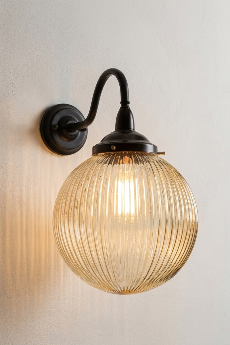 Medium amber reeded glass ball shade on a large gooseneck outdoor wall arm in black. 