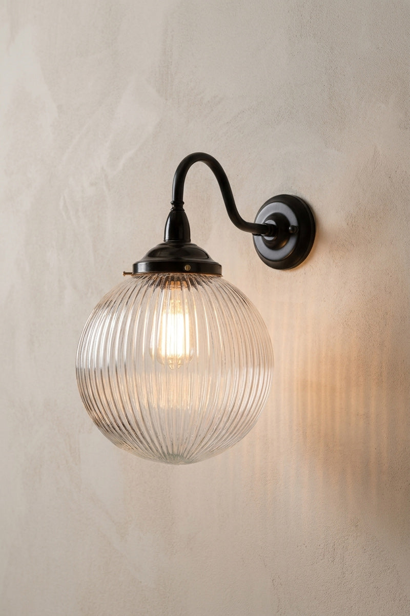 Medium clear reeded glass ball shade on a large gooseneck outdoor wall arm in black. 