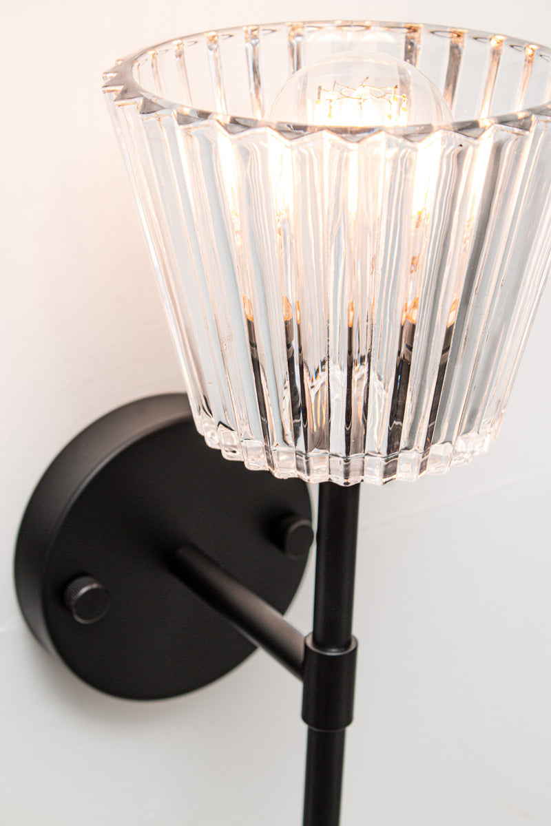 Close-up of Davis Glass Stem Wall Light showing clear vertically fluted glass and black steel fitting.