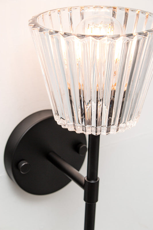 Close-up of Davis Glass Stem Wall Light showing clear vertically fluted glass and black steel fitting.
