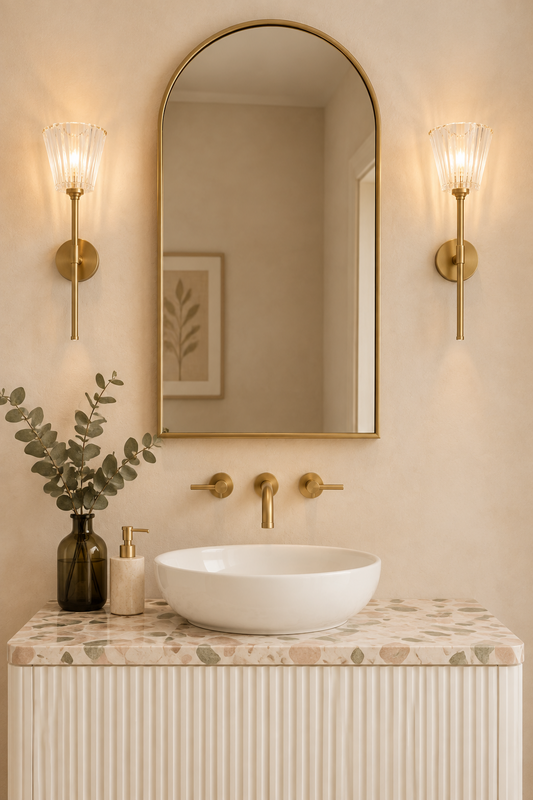 gold brass wall sconces with decorative glass shades in ensuite bathroom