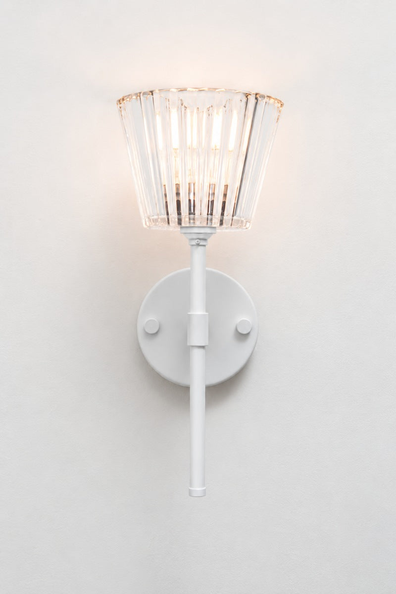 Front view of white Davis Glass Stem Light illuminated against a white wall.