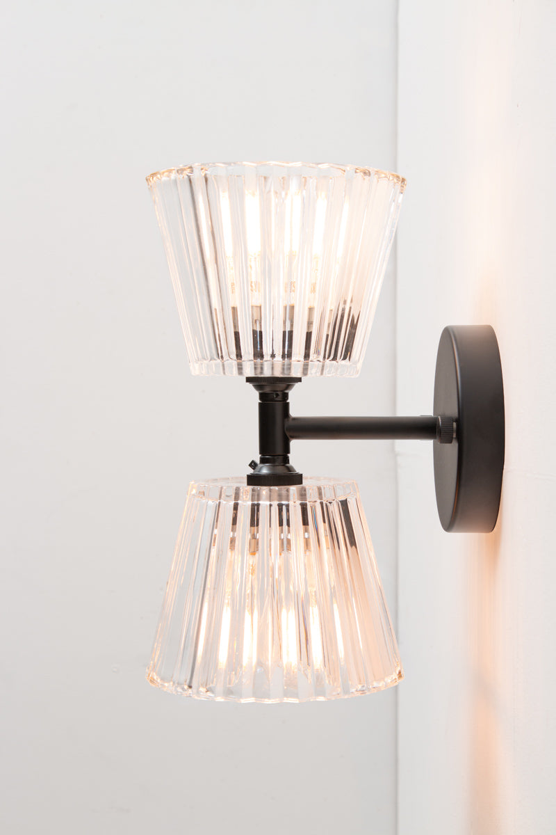 Side view of Davis Glass Double Light Wall Sconce with black fixture and clear fluted glass shades