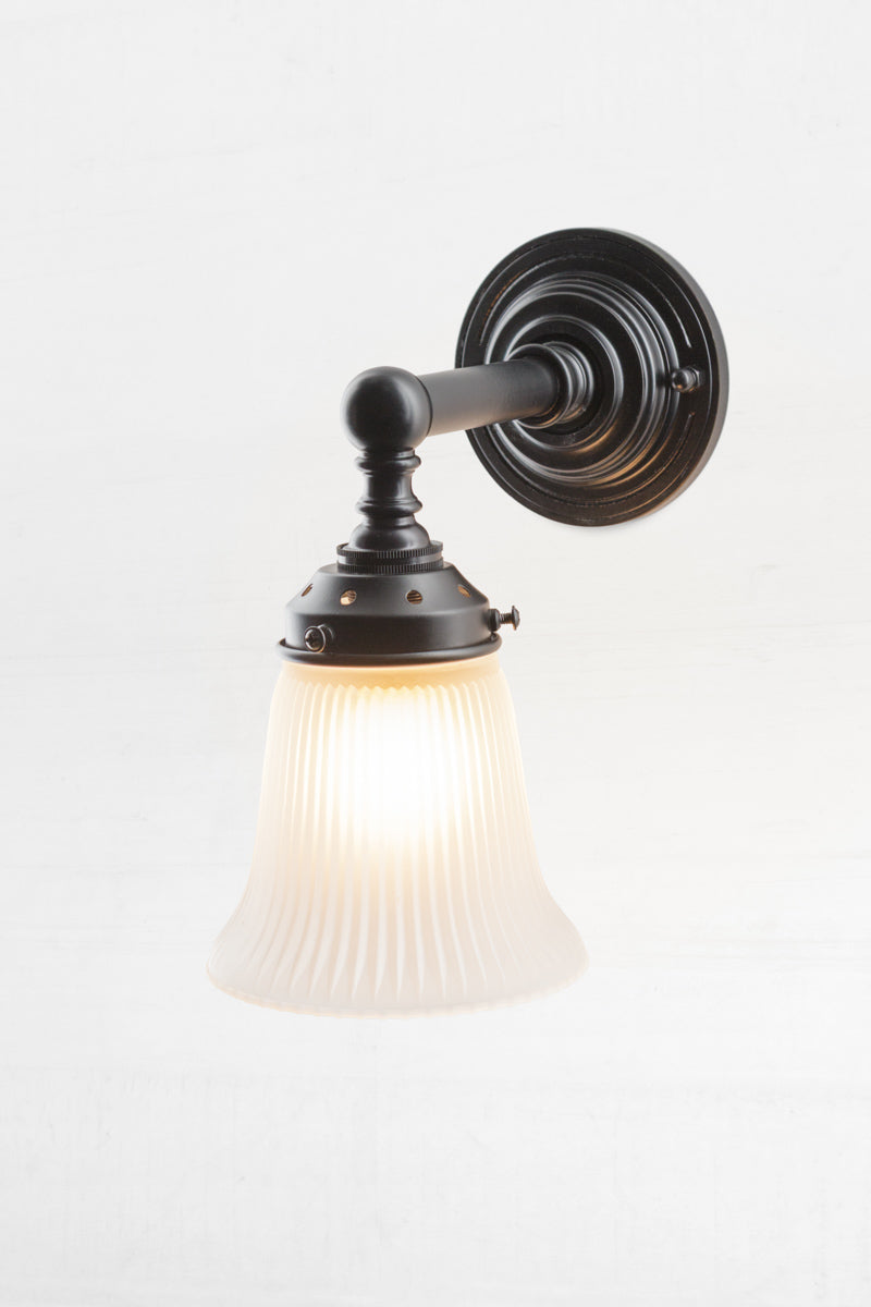 Vintage and industrial wall light. With an opal holophane glass shade.  