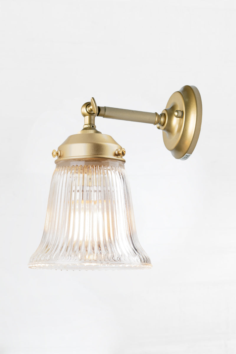 Clear glass ribbed shade wih a gold/brass short straight wall arm. 