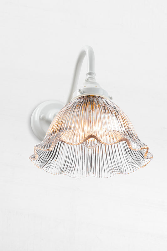 White gooseneck wall arm with a clear reeded, frill edged shade. 