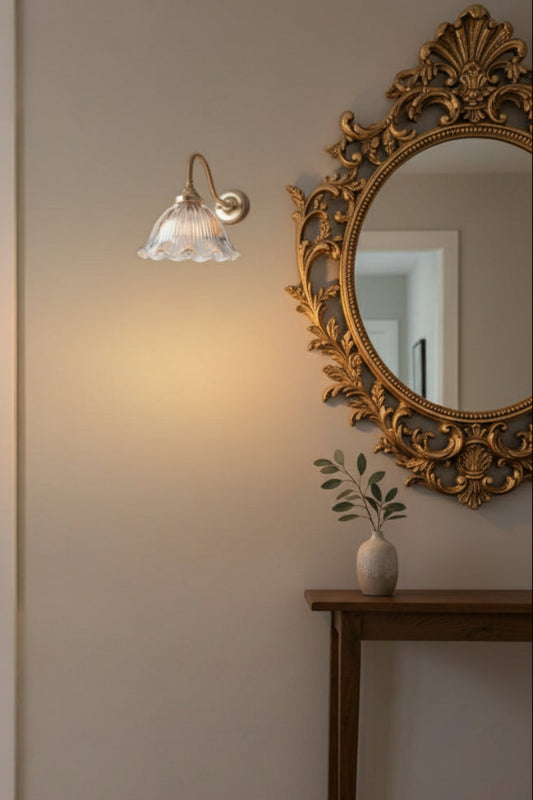 Gold/brass gooseneck arm next to a side table and mirror