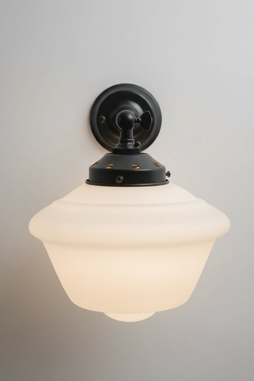 Fron view of the opal glass schoolhouse style shade on the black straight arm wall sconce.