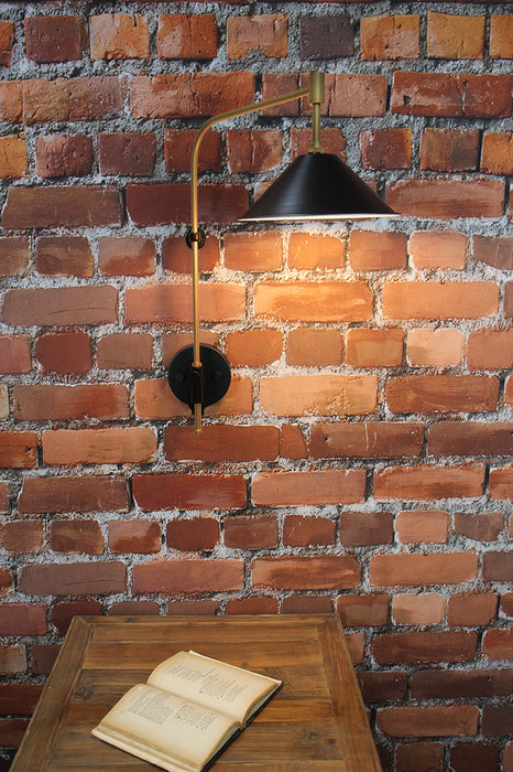 wing arm wall light with black cone shade and gold/brass finish