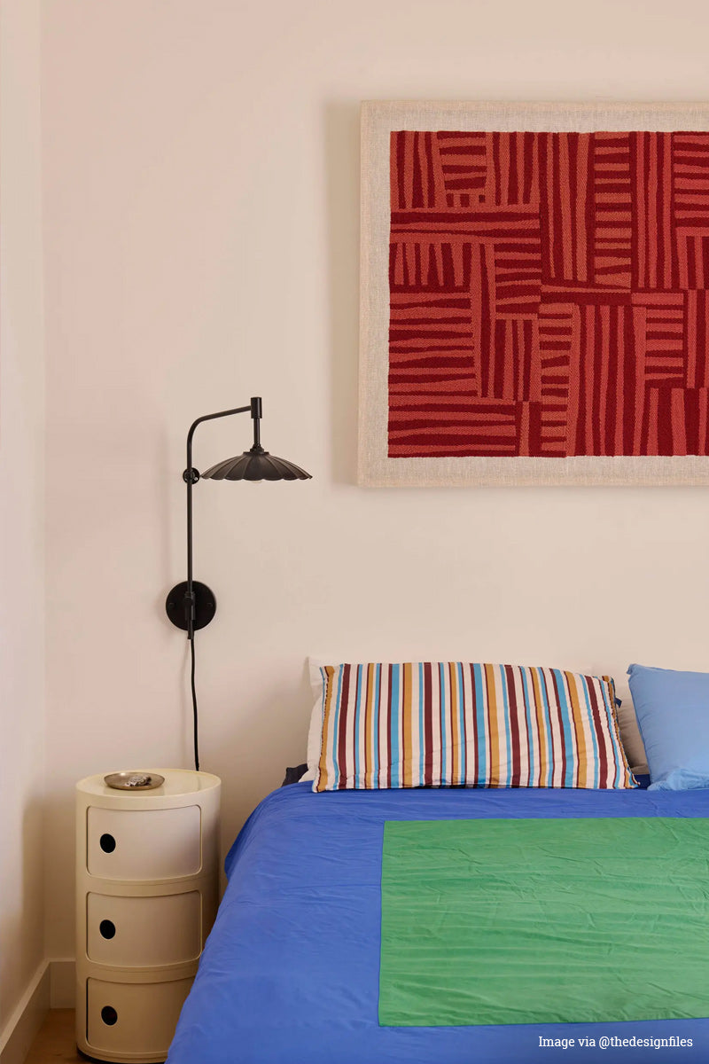 Image via @designfiles. Plug in swing arm wall light with a black small umberlla shade, with mid centry colourful decor. 