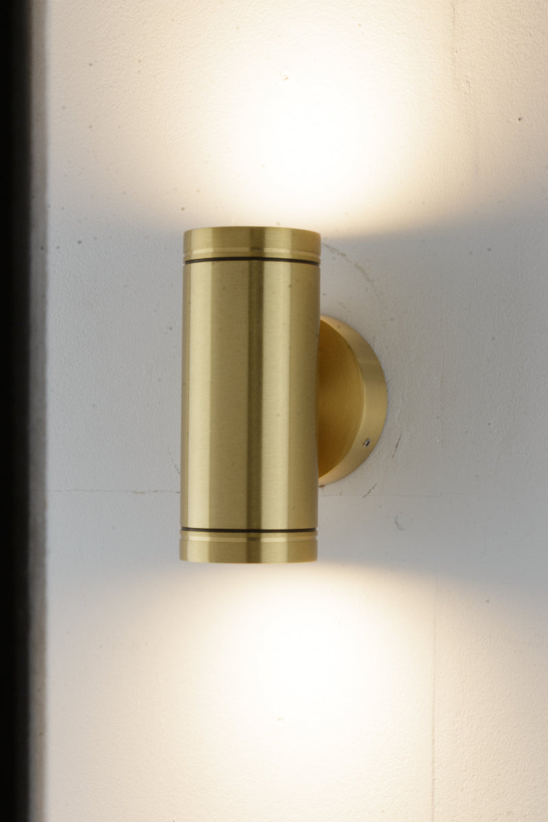 solid brass wall-mounted up down spotlight fixture on a white outside wall