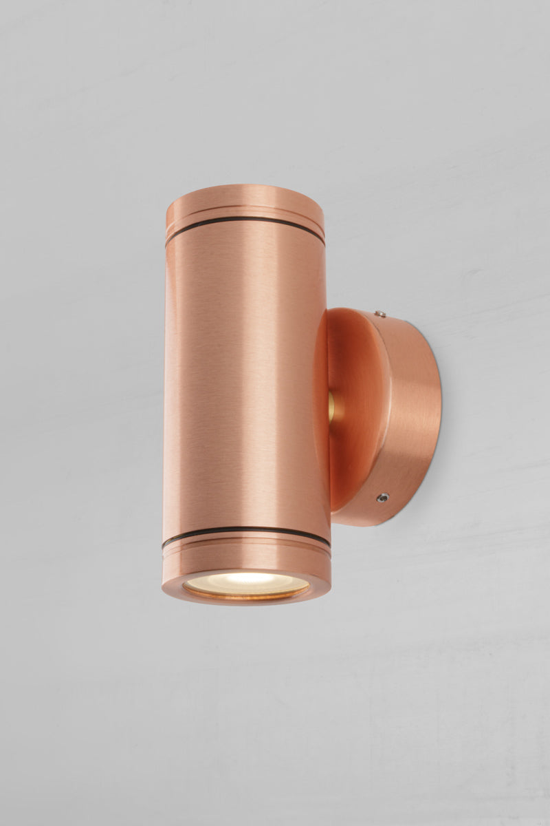 Side view of the solid copper up/down wall spot light with a polished finish. 