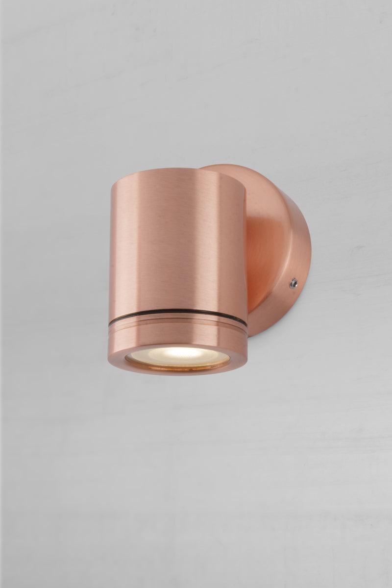 Single compact solid copper outdoor spotlight with polished finish.