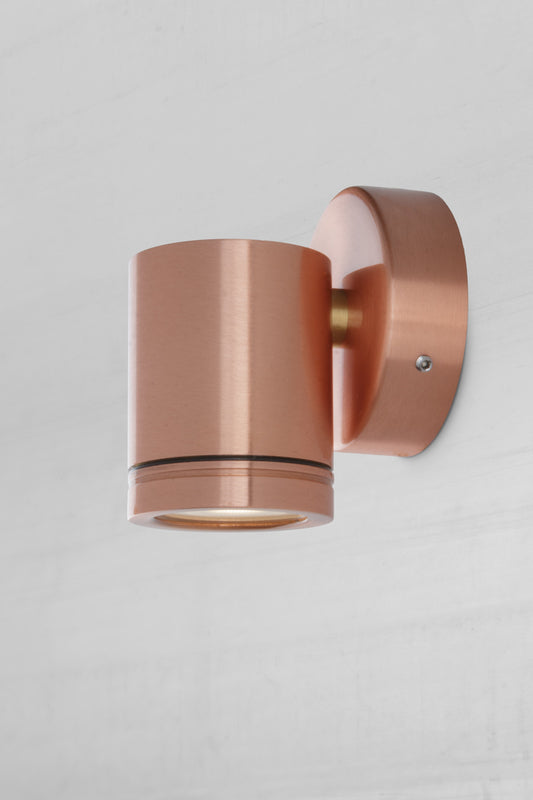 Side view of the single light, solid copper spotlight with polished finish.