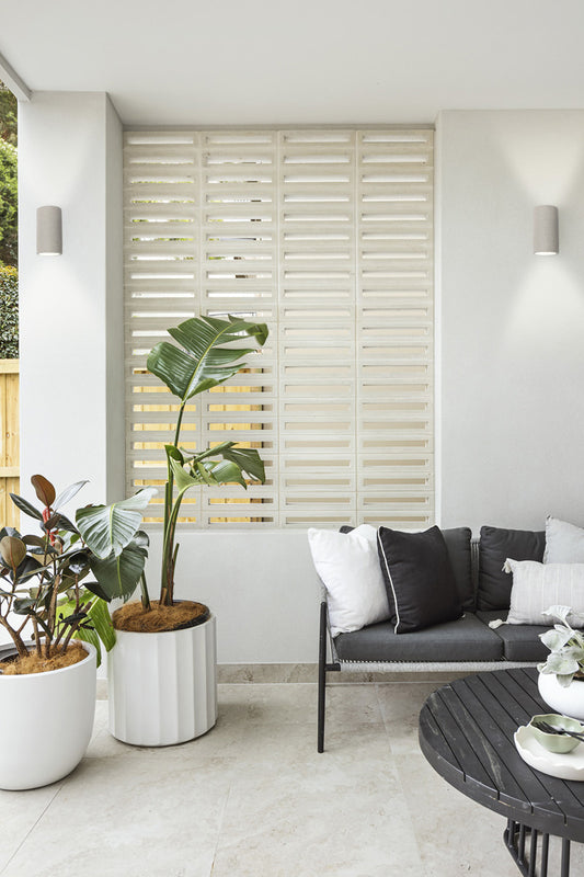 outdoor wall ights in patio setting of white walls and dark couches